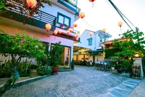 a courtyard of a building with lanterns and plants at Daisy Garden Villa Hoi An in Hoi An