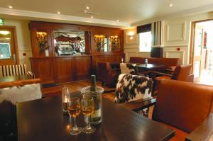 a restaurant with two glasses of wine on tables at Ashford Court Boutique Hotel in Ennis