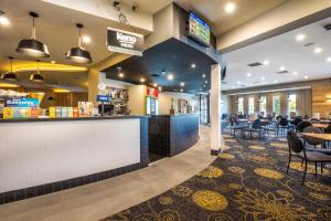 a restaurant with a bar and tables and chairs at Nightcap at Carlyle Hotel in Derwent Park