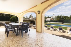 een patio met een tafel en stoelen en een zwembad bij Jasmin in Jávea