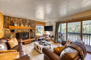 a living room with couches and a tv and a fireplace at Timberfalls Hideaway in Vail