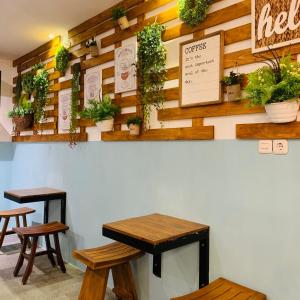 a room with two tables and some plants on the wall at The Nalaya Hotel & Resto in Borobudur