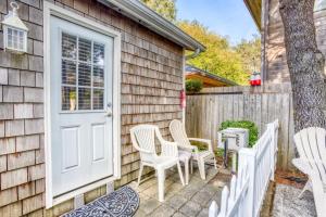 a patio with white chairs and a door at Beaches Inn | Pirates Cove Cabana 8 in Cannon Beach
