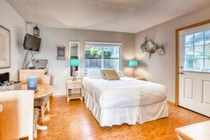 a bedroom with a bed and a desk and a window at Beaches Inn | Pirates Cove Cabana 8 in Cannon Beach