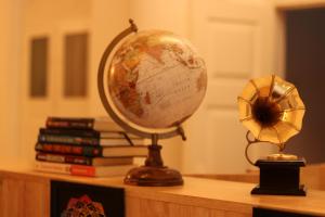 a globe and a fan on a table with books at Roambay in Mysore