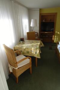 um quarto com uma mesa e cadeiras e uma televisão em Ferienwohnungen Hildegund em Uschlag