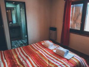 1 dormitorio con 1 cama con toallas en Terra Nostra en Córdoba