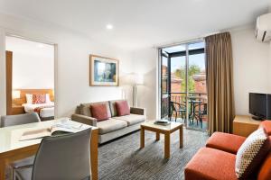 a living room with a couch and a table at Quest St Kilda Bayside in Melbourne