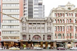 a large building with cars parked in front of it at WOW Apartment on Flinders in Melbourne