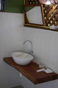 baño con lavabo blanco en una encimera de madera en Kham Ecolodge, en Chiang Saen