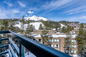 a view from a balcony of a building with a snow covered mountain at Shoshone Condo 1957 in Big Sky