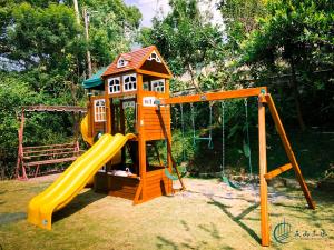 a playground with a slide and a house at Five mountains and Three Water B&B in Shuili