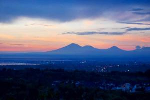 una vista de una puesta de sol con montañas en el fondo en The Longhouse, Jimbaran - Bali, en Jimbaran