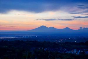 a view of a sunset with mountains in the background at The Longhouse, Jimbaran - Bali in Jimbaran