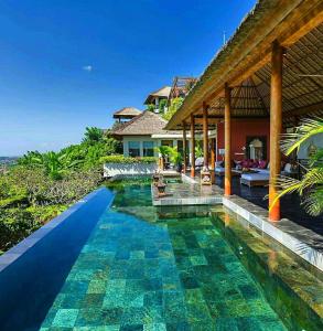 a swimming pool in front of a villa at The Longhouse, Jimbaran - Bali in Jimbaran