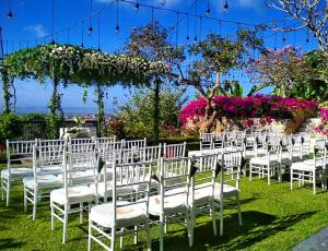 una fila de sillas blancas para una ceremonia de boda en The Longhouse, Jimbaran - Bali, en Jimbaran