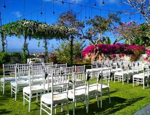 a row of white chairs for a wedding ceremony at The Longhouse, Jimbaran - Bali in Jimbaran