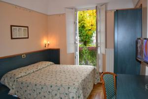 a bedroom with a bed and a window at Albergo Italia in Varallo