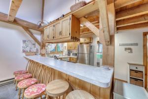 a kitchen with wooden cabinets and bar stools at Sherwood Escape in Londonderry