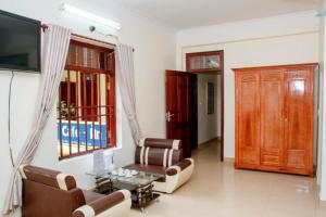a living room with a couch and chairs and a tv at Homestay Xuandung in Ninh Binh