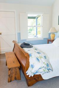 a bedroom with a bed and a table and a window at Akaroa Streamside Cottage in Akaroa