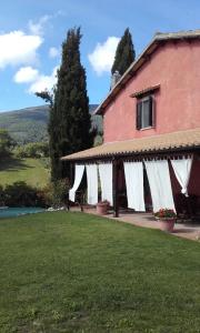 斯波萊托的住宿－Colle Cornetto，白色窗帘和庭院的房子