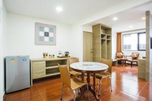 a kitchen and dining room with a table and a refrigerator at The K Hotel in Nagoya