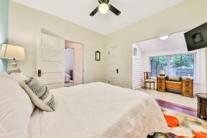 Un dormitorio blanco con una cama grande y una ventana en Charming Myrtle Bungalow en St. Augustine