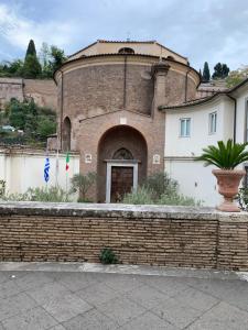 un bâtiment avec un mur en briques et des drapeaux devant lui dans l'établissement Suites in Rome 2, à Rome