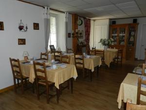 une salle à manger avec des tables, des chaises et un tissu de table jaune dans l'établissement Hotel du Mont Blanc, à Sallanches