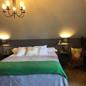 Un dormitorio con una cama grande y una lámpara de araña. en B&B Het Welthof en Bree