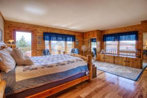1 dormitorio con cama, paredes y ventanas de madera en Mills Ranch en Woodland Park