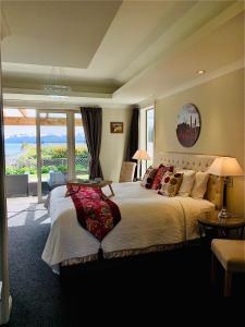 1 dormitorio con 1 cama grande y vistas al océano en Tekapo Heights, en Lake Tekapo