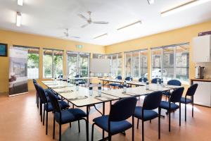 une salle de conférence avec des tables, des chaises et des fenêtres dans l'établissement Quest St Kilda Bayside, à Melbourne