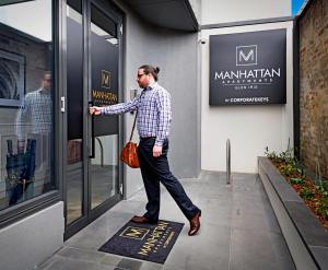 Ein Mann verlässt ein Gebäude in der Unterkunft Manhattan Apartments - Glen Iris in Melbourne