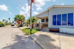 a house with a palm tree next to a street at Long Island Village Unit 111 in Port Isabel