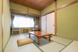 pokój z drewnianym stołem w pokoju z oknem w obiekcie Hanamizuki w mieście Yamanakako