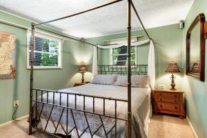 1 dormitorio con cama con dosel y paredes verdes en River Romance, en Sylva