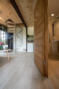 an open hallway with a wooden door and a kitchen at Petit Maison du Chêne in Auriac-du-Périgord