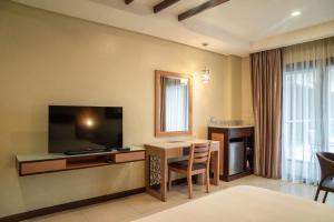 a hotel room with a desk and a television and a table at Cebu Westown Lagoon - South Wing in Cebu City