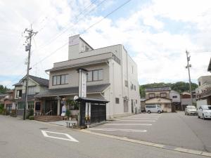 un edificio blanco al lado de una calle en Hanagoyomi, en Nanao