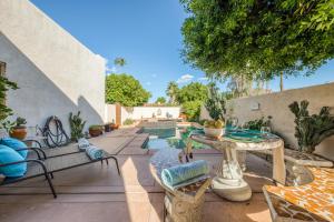 un patio con mesa, sillas y piscina en Villa Obregon Permit# 67311, en La Quinta