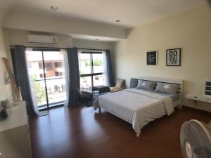 a bedroom with a white bed and a large window at PaperPlane Haiya Nordic House in Chiang Mai