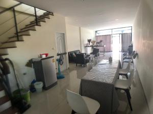 a living room with a table and chairs and a staircase at PaperPlane Haiya Nordic House in Chiang Mai