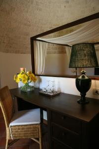 a desk with a lamp and flowers on it at Abate Masseria & Resort in Noci