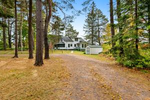 a dirt road in front of a house with trees at White House in Katinka Village