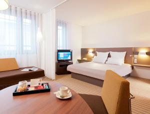 pokój hotelowy z łóżkiem i telewizorem w obiekcie Novotel Suites Paris Montreuil Vincennes w Paryżu