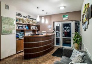 a bar in a restaurant with a couch and a counter at Willa Nad Dunajcem in Nowy Targ