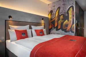 a bedroom with a large white bed with red pillows at the niu Hide in Berlin