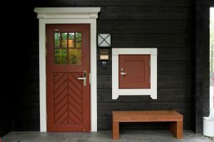 czerwone drzwi i ławka na boku domu w obiekcie The Prince Villa Karuizawa w mieście Karuizawa